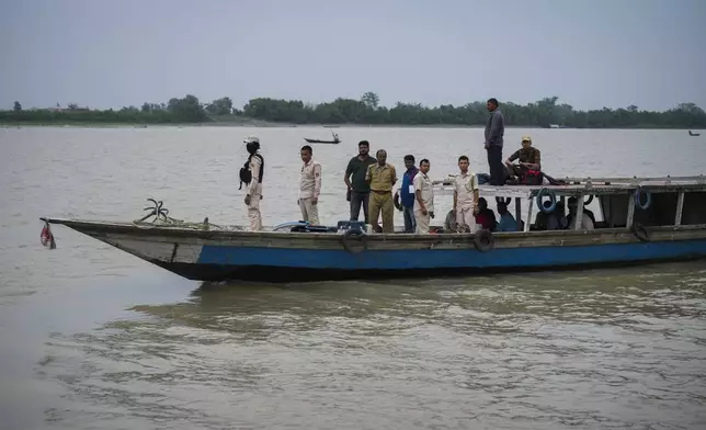 Election officials carrying Electronic Voting Machines(EVMs) and other polling material, travel on a boat to their respective polling booths in a char in the river Brahmaputra on the eve of the third phase of India's national elections, in Garoimari village on the outskirts of Guwahati, India, Monday, May 6, 2024. (AP Photo/Anupam Nath)