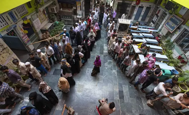 People queue up to cast their vote in the sixth round of polling in India's national election in New Delhi, India, Saturday, May 25, 2024. (AP Photo/Altaf Qadri)
