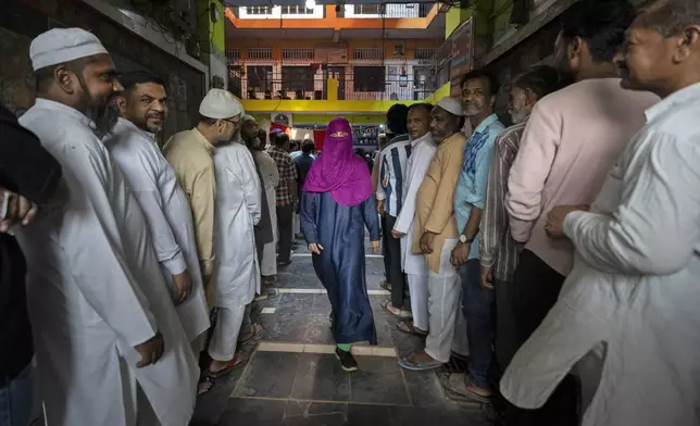 A voter leaves after casting her vote as others queue up to cast their vote in the sixth round of polling in India's national election in New Delhi, India, Saturday, May 25, 2024. (AP Photo/Altaf Qadri)