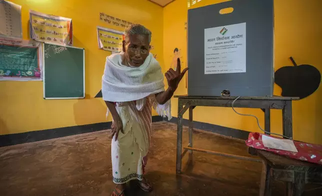 An elderly woman shows the indelible ink mark on her index finger after casting vote in a polling station during the third phase of general election on the outskirts of Guwahati, India, Tuesday, May 7, 2024. (AP Photo/Anupam Nath)