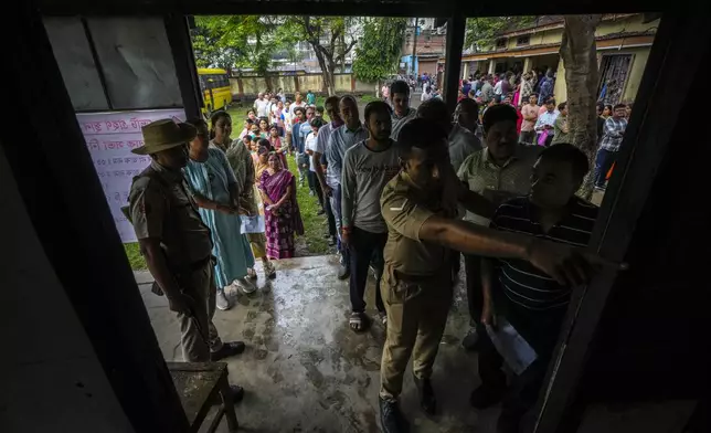 People queue up to cast their votes in a polling station during the third phase of general election in Guwahati, Assam, India, Tuesday, May 7, 2024. (AP Photo/Anupam Nath)