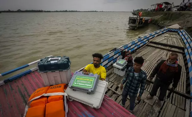 Election officials carrying Electronic Voting Machines (EVMs) and other polling material prepare to cross the river Brahmaputra to reach their polling booths on the eve of the third phase of India's national elections at Garoimari village, outskirts of Guwahati, Assam, India, Monday, May 6, 2024. (AP Photo/Anupam Nath)