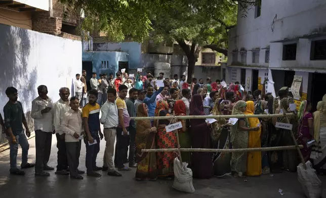 People stand in queue to vote during the third round of voting in the six-week-long general election in Agra, Uttar Pradesh, India, Tuesday, May 7, 2024. (AP Photo/Altaf Qadri)