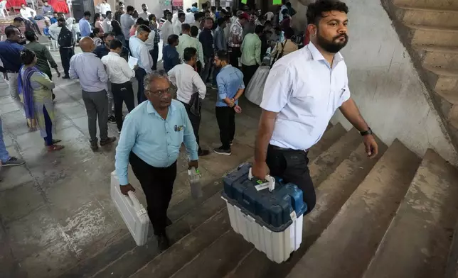 Election officials carrying Electronic Voting Machines(EVMs) and other polling material head to their respective polling booths on the eve of the third phase of India’s national elections, in Ahmedabad, Gujarat state, India, Monday, May 6, 2024. (AP Photo/Ajit Solanki)