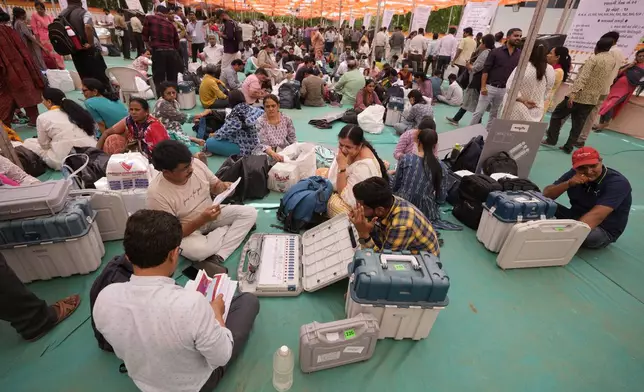 Election officials check Electronic Voting Machines(EVMs) and other polling material before they head to their respective polling booths on the eve of the third phase of India’s national elections, in Ahmedabad, Gujarat state, India, Monday, May 6, 2024. (AP Photo/Ajit Solanki)