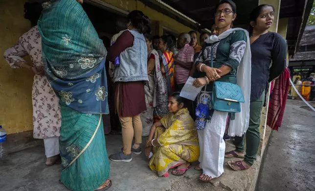 People stand on queue to cast their votes in a polling station during the third phase of general election in Guwahati, Assam, India, Tuesday, May 7, 2024. (AP Photo/Anupam Nath)