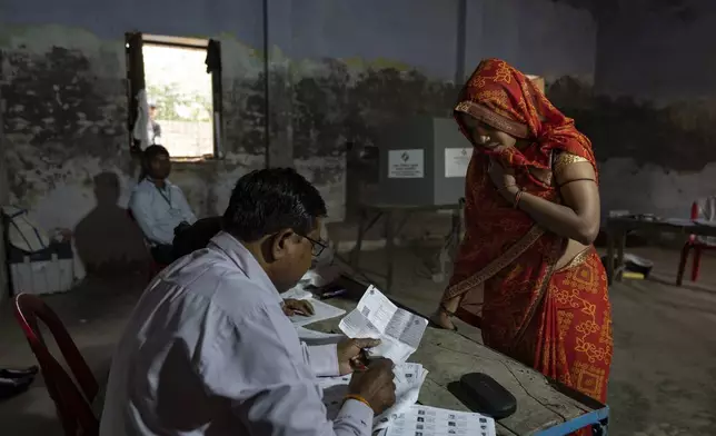A woman arrives to cast her vote during the third round of voting in the six-week-long general election in Agra, Uttar Pradesh, India, Tuesday, May 7, 2024. (AP Photo/Altaf Qadri)