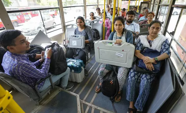Election officials carrying Electronic Voting Machines(EVMs) sit in a bus as they head to their respective polling booths on the eve of the third phase of India’s national elections, in Ahmedabad, Gujarat state, India, Monday, May 6, 2024. (AP Photo/Ajit Solanki)