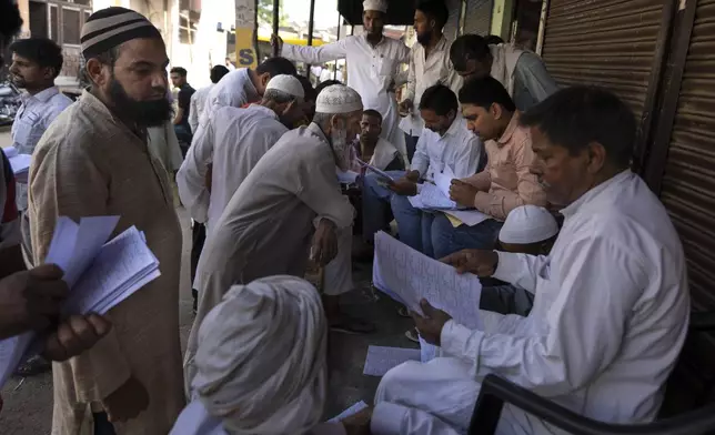 Muslims check for their names in voters' list as they arrive to vote in Nahal village, Uttar Pradesh state, India, on April 26, 2024. (AP Photo/Altaf Qadri)