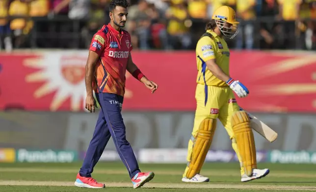 Chennai Super Kings' MS Dhoni, right, walks off the field after losing his wicket to Punjab Kings' Harshal Patel, left, during the Indian Premier League cricket match between Chennai Super Kings and Punjab Kings in Dharamshala, India, Sunday, May 5, 2024. (AP Photo /Ashwini Bhatia)
