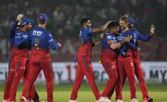 Royal Challengers Bengaluru's Karn Sharma, third right, is congratulated by teammates for taking the wicket of Punjab Kings' Rilee Rossouw during the Indian Premier League cricket match between Punjab Kings and Royal Challengers Bengaluru in Dharamshala, India, Thursday, May 9, 2024. (AP Photo /Ashwini Bhatia)