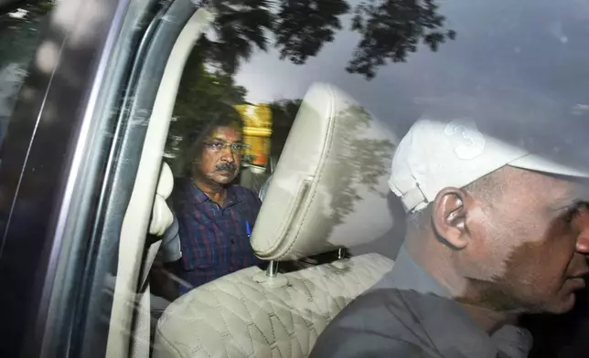 FILE- Arvind Kejriwal, leader of the Aam Admi Party, or Common Man's Party, left, leaves in a car after a court extended his custody for four more days, in New Delhi, India, March 28, 2024. India's top court on Friday gave interim bail to the top opposition leader who was arrested nearly seven weeks ago. (AP Photo/Dinesh Joshi, File)