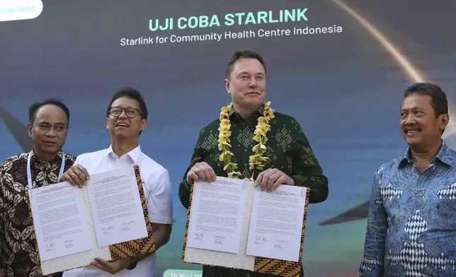 Indonesian Minister of Health Budi Gunadi Sadikin, second from left, and Elon Musk, second from right, sign an agreement on enhancing connectivity at a public health center in Denpasar, Bali, Indonesia on Sunday, May 19, 2024. Elon Musk arrived in Indonesia's resort island of Bali to launch Starlink satellite internet service in the world's largest archipelago nation. (AP Photo/Firdia Lisnawati)