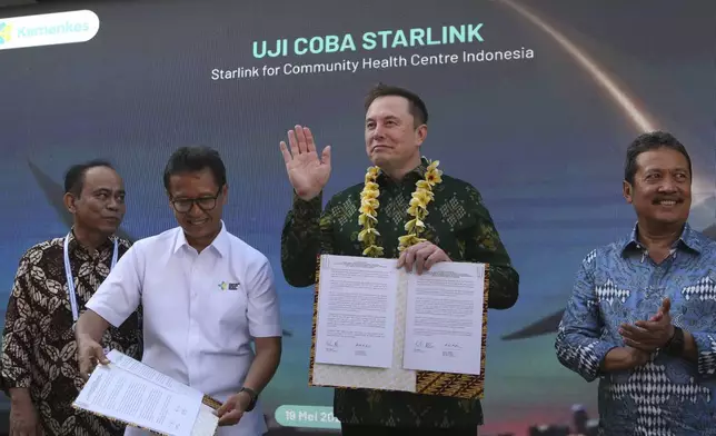 Indonesian Minister of Health, Budi Gunadi Sadikin, second from left, and Elon Musk, second from right, pose after signing an agreement on enhancing connectivity at a public health center in Denpasar, Bali, Indonesia on Sunday, May 19, 2024. Elon Musk arrived in Indonesia's resort island of Bali to launch Starlink satellite internet service in the world's largest archipelago nation. (AP Photo/Firdia Lisnawati)