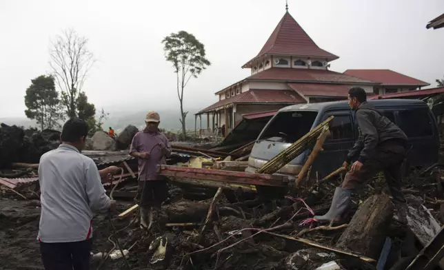 People inspect the damage by a flash flood in Agam, West Sumatra, Indonesia, Tuesday, May 14, 2024. Rescuers on Tuesday searched in rivers and the rubble of devastated villages for bodies, and whenever possible, survivors of flash floods that hit Indonesia's Sumatra Island over the weekend. (AP Photo/Fachri Hamzah)