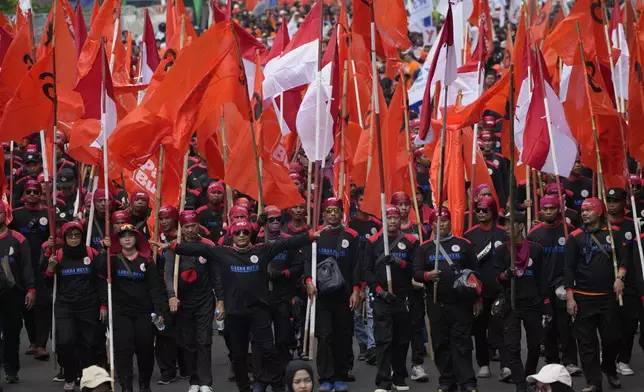 Workers march during a May Day rally in Jakarta, Indonesia, Wednesday, May 1, 2024. Thousands of workers urged the government to raise minimum wages and improve working condition. (AP Photo/Achmad Ibrahim)