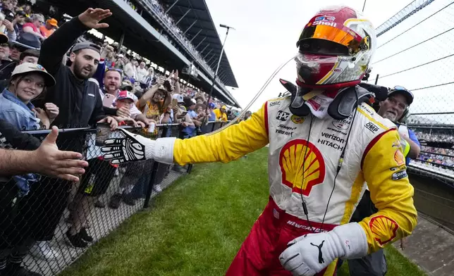 Josef Newgarden celebrates with fans in the stands after winning the Indianapolis 500 auto race at Indianapolis Motor Speedway in Indianapolis, Sunday, May 26, 2024. (AP Photo/AJ Mast)