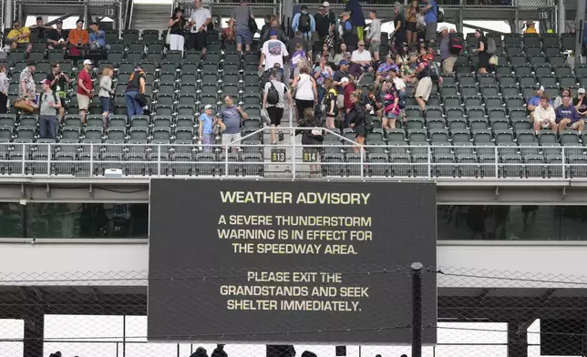 Fans exit the grandstands after a serve thunderstorm warning was issued for the area around the Indianapolis 500 auto race at Indianapolis Motor Speedway in Indianapolis, Sunday, May 26, 2024. (AP Photo/AJ Mast)
