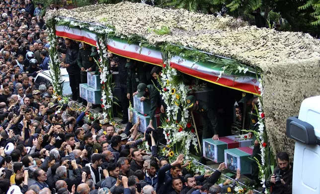 In this photo provided by Fars News Agency, mourners gather around a truck carrying coffins of Iranian President Ebrahim Raisi and his companions who were killed in their helicopter crash on Sunday in a mountainous region of the country's northwest, during a funeral ceremony at the city of Tabriz, Iran, Tuesday, May 21, 2024. Mourners in black began gathering Tuesday for days of funerals and processions for Iran's late president, foreign minister and others killed in a helicopter crash, a government-led series of ceremonies aimed at both honoring the dead and projecting strength in an unsettled Middle East. (Ata Dadashi, Fars News Agency via AP)