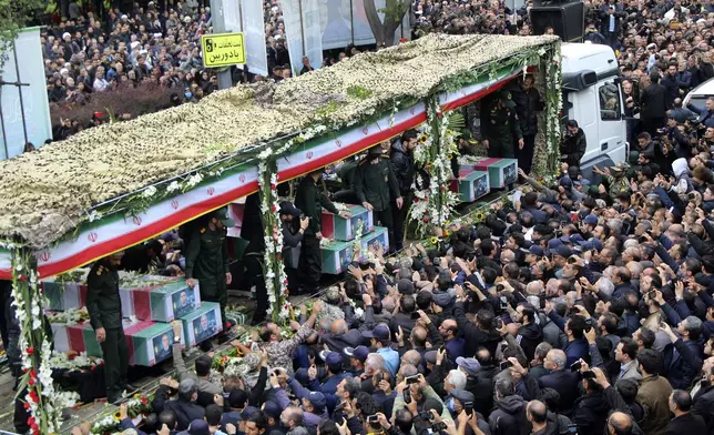In this photo provided by Fars News Agency, mourners gather around a truck carrying coffins of Iranian President Ebrahim Raisi and his companions who were killed in their helicopter crash on Sunday in mountainous region of the country's northwest, during a funeral ceremony at the city of Tabriz, Iran, Tuesday, May 21, 2024. Mourners in black began gathering Tuesday for days of funerals and processions for Iran's late president, foreign minister and others killed in a helicopter crash, a government-led series of ceremonies aimed at both honoring the dead and projecting strength in an unsettled Middle East. (Ata Dadashi/Fars News Agency via AP)