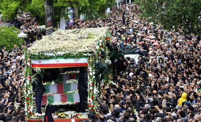 In this photo provided by Fars News Agency, mourners gather around a truck carrying coffins of Iranian President Ebrahim Raisi and his companions who were killed in their helicopter crash on Sunday in mountainous region of the country's northwest, during a funeral ceremony at the city of Tabriz, Iran, Tuesday, May 21, 2024. Mourners in black began gathering Tuesday for days of funerals and processions for Iran's late president, foreign minister and others killed in a helicopter crash, a government-led series of ceremonies aimed at both honoring the dead and projecting strength in an unsettled Middle East. (Ata Dadashi, Fars News Agency via AP)
