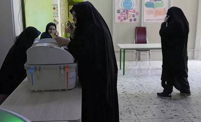 An Iranian woman votes for the parliamentary runoff elections at a polling station in Tehran, Iran, Friday, May 10, 2024. Iranians voted Friday in a runoff election for the remaining seats in the country's parliament after hard-line politicians dominated March balloting. (AP Photo/Vahid Salemi)