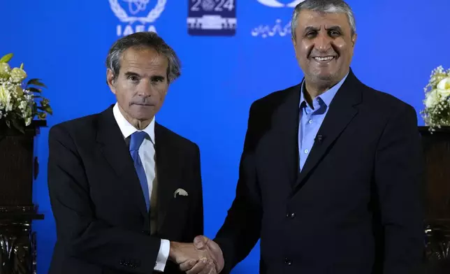International Atomic Energy Organization, IAEA, Director General Rafael Grossi, left, and head of Iran's atomic energy department Mohammad Eslami shake hands at the conclusion of their joint press conference after their meeting in the central city of Isfahan, Iran, Tuesday, May 7, 2024. (AP Photo/Vahid Salemi)