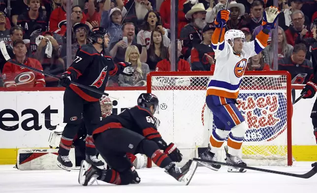 New York Islanders' Bo Horvat (14) celebrates a goal by teammate Casey Cizikas, not pictured, during the second period in Game 5 of an NHL hockey Stanley Cup first-round playoff series against the Carolina Hurricanes in Raleigh, N.C., Tuesday, April 30, 2024. (AP Photo/Karl B DeBlaker)