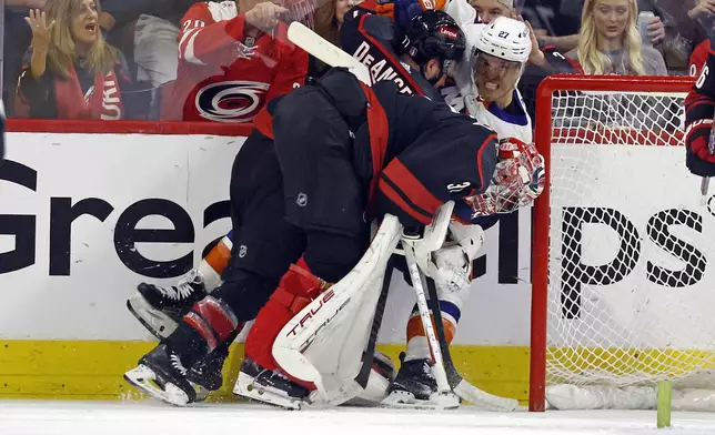 Carolina Hurricanes' Tony DeAngelo (77) and goaltender Frederik Andersen (31) tangle with New York Islanders' Anders Lee (27) during the second period in Game 5 of an NHL hockey Stanley Cup first-round playoff series in Raleigh, N.C., Tuesday, April 30, 2024. (AP Photo/Karl B DeBlaker)