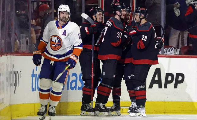 Carolina Hurricanes' Andrei Svechnikov (37) celebrates his goal with Sebastian Aho (20) as New York Islanders' Cal Clutterbuck (15) skates by during the first period in Game 5 of an NHL hockey Stanley Cup first-round playoff series in Raleigh, N.C., Tuesday, April 30, 2024. (AP Photo/Karl B DeBlaker)