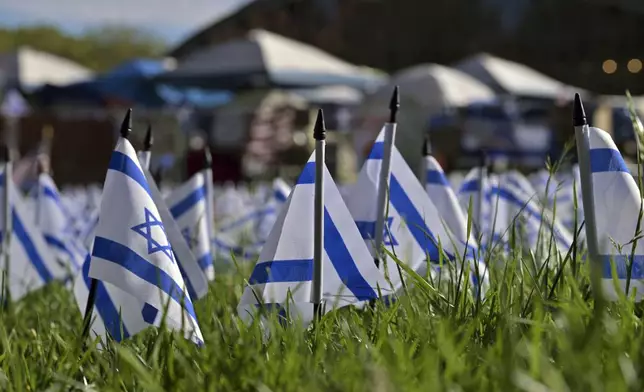 A field of Israeli flags stand on the lawn beside a Pro-Palestinian encampment at MIT, Thursday, May 9, 2024, in Cambridge, Mass. MIT has suspended 23 students for participating in the encampment, and police detained at least three during a demonstration at the nearby Stata center, where demonstrators blocked traffic over claims the university was conducting research which would be used for Israeli military drones. (AP Photo/Josh Reynolds)