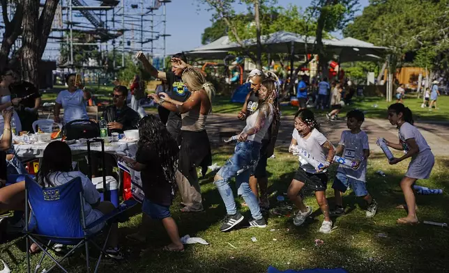 Children joke around as they spend the day during Israel's Independence Day celebrations, at a park, in Tel Aviv, Tuesday, May 14, 2024. Israelis are marking 76 years since Israel's creation. (AP Photo/Ohad Zwigenberg)