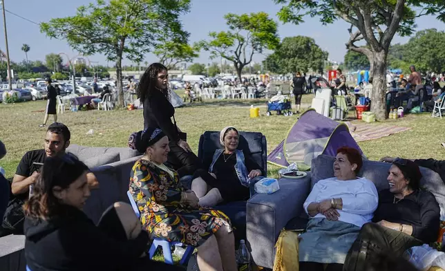 People talk as they sit on sofas during Israel's Independence Day celebrations at a park in Tel Aviv, Tuesday, May 14, 2024. Israelis are marking 76 years since Israel's creation. (AP Photo/Ohad Zwigenberg).