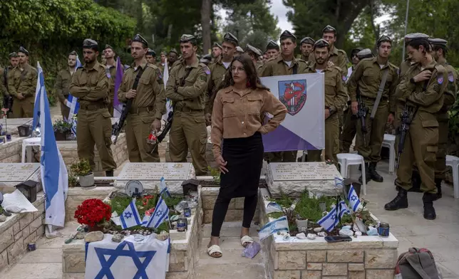 Israeli soldiers and family members of fallen soldiers visit their graves on the eve of the country's annual Memorial Day for fallen soldiers and victims of nationalistic attacks, at Mount Herzl military cemetery, in Jerusalem, Sunday, May 12, 2024. (AP Photo/Ohad Zwigenberg)