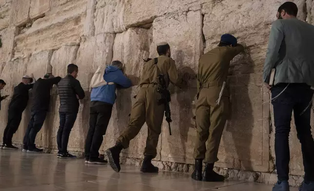 Israeli soldiers pray after attending the ceremony marking Israel's annual Memorial Day for fallen soldiers and victims of nationalistic attacks at the Western Wall, the holiest site where Jews can pray, in the Old City of Jerusalem, Sunday, May 12, 2024. (AP Photo/Leo Correa)