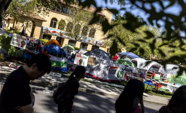A group of prospective students walk by a tent encampment in White Plaza in support of Palestinians during a campus tour at Stanford University, in Stanford, Calif., Tuesday, April 30, 2024.(Stephen Lam/San Francisco Chronicle via AP)