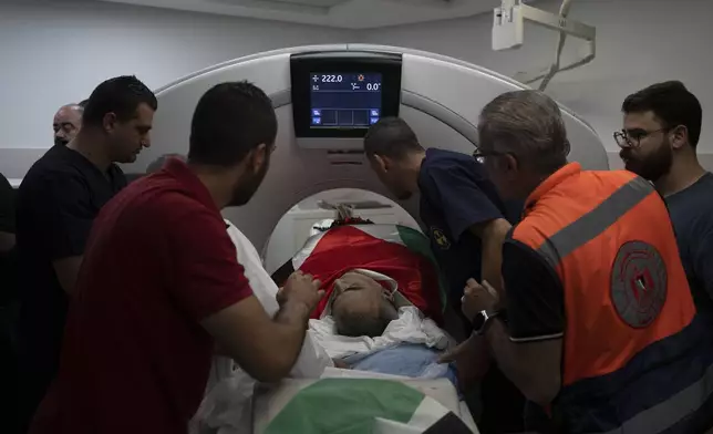 Palestinians place the body of the doctor Ossayed Kamal Jabareen on a CT scan before his funeral at the government hospital in the West Bank city of Jenin, Thursday, May 23, 2024. The Israeli military said Thursday it has completed a two-day operation in the occupied West Bank that the Palestinian Health Ministry says killed 12 Palestinians. Militant groups claimed at least eight of the dead as fighters, one from Hamas and seven from the Al-Aqsa Martyrs Brigade. (AP Photo/Leo Correa)