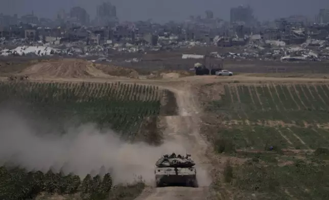 Israeli soldiers move on the top of a tank near the Israeli-Gaza border, as seen from southern Israel, Thursday, May 16, 2024. (AP Photo/Leo Correa)