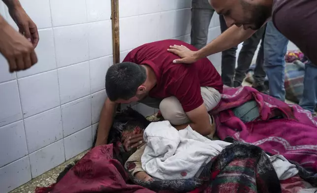 Palestinians mourn the bodies of their relatives killed in an Israeli bombardment of the Gaza Strip, at the Al Aqsa hospital in Deir al Balah, central Gaza Strip, on Monday, May 27, 2024. (AP Photo/Abdel Kareem Hana)