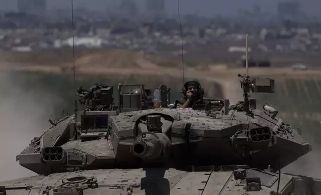 Israeli soldiers move on the top of a tank near the Israeli-Gaza border, as seen from southern Israel, Thursday, May 16, 2024. (AP Photo/Leo Correa)