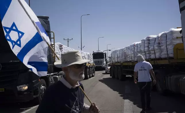 People block a road as they try to stop the trucks, carrying humanitarian aid, to enter in the Gaza Strip in an area near the Kerem Shalom border crossing between Israel and Gaza, in southern Israel, in Kerem Shalom, Thursday, May 9, 2024. (AP Photo/Leo Correa)