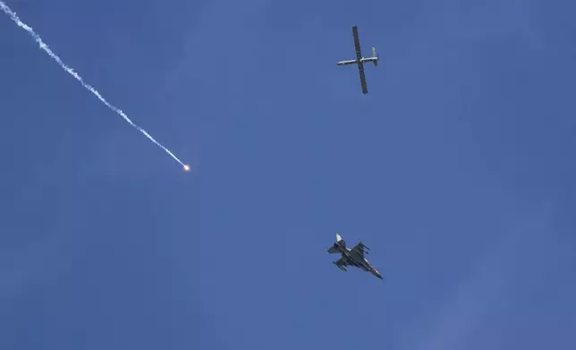An Israeli fighter jet releases flares, and a drone is seen from Rafah, Gaza Strip, on Tuesday, May 28, 2024. (AP Photo/Abdel Kreem Hana)