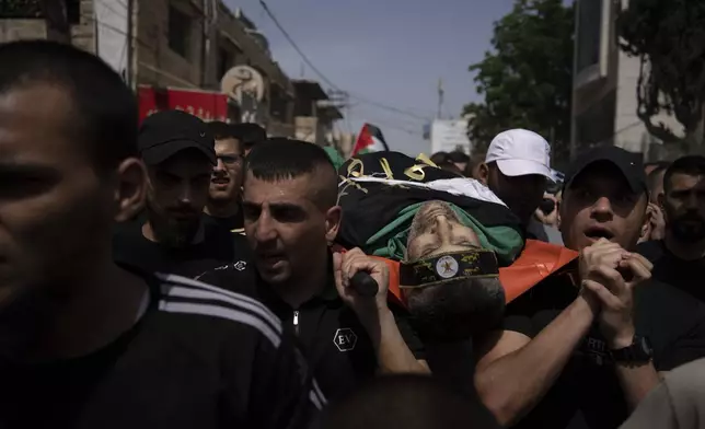 Mourners carry the body of a Palestinian draped in the Islamic Jihad militant group flag during his funeral in the West Bank city of Jenin, Thursday, May 23, 2024. The Israeli military said Thursday it has completed a two-day operation in the occupied West Bank that the Palestinian Health Ministry says killed 12 Palestinians. Militant groups claimed at least eight of the dead as fighters, one from Hamas and seven from the Al-Aqsa Martyrs Brigade. (AP Photo/Leo Correa)