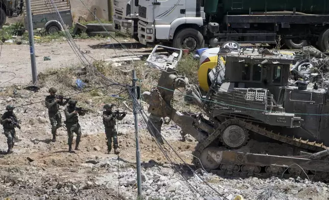 Israeli solider aims their weapons during military operation in the town of Deir al-Ghusun, near the West Bank town of Tulkarem, Saturday, May 4, 2024. (AP Photo/Majdi Mohammed)