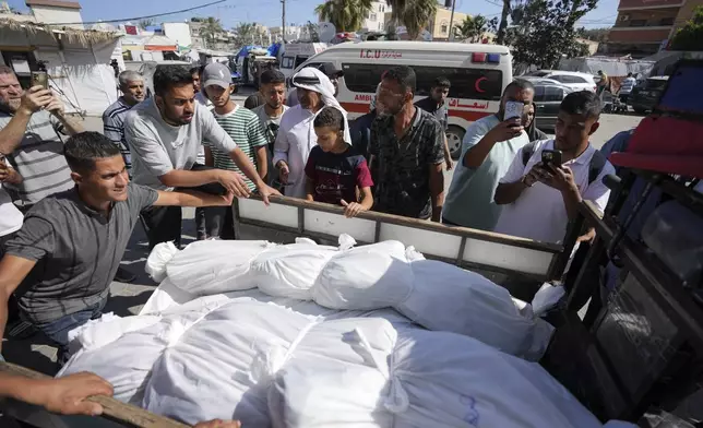 The bodies of Palestinians are moved to their burial, a day after they were killed by Israeli bombardment, at Al Aqsa Hospital in Deir al Balah, Friday, May 24, 2024. (AP Photo/Abdel Kareem Hana)