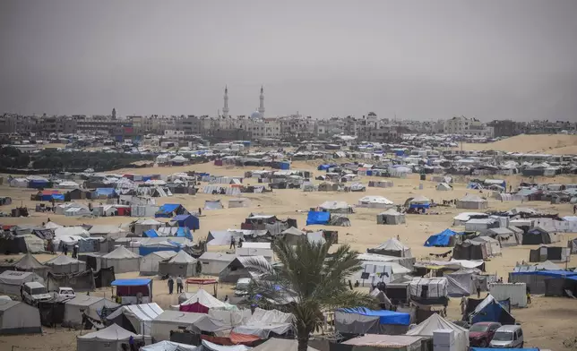 Palestinians displaced by the Israeli air and ground offensive on the Gaza Strip walk through a makeshift tent camp in Rafah, Gaza, Friday, May 10, 2024. (AP Photo/Abdel Kareem Hana)