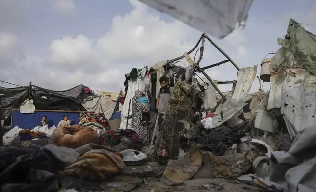 Displaced Palestinians inspect their tents destroyed by Israel's bombardment, adjunct to an UNRWA facility west of Rafah city, Gaza Strip, Tuesday, May 28, 2024. (AP Photo/Jehad Alshrafi)