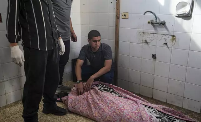 Mourners look at the bodies of Palestinians who were killed in an Israeli airstrike in Gaza Stirp, at the Al Aqsa hospital in Deir al Balah, Gaza, Thursday, May 2, 2024. (AP Photo/Abdel Kareem Hana)