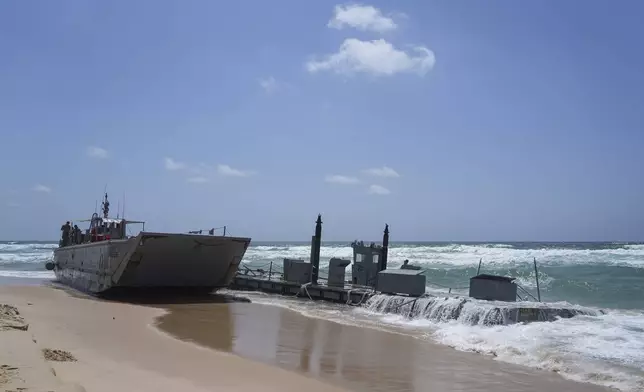 A washed up US Army vessel and a strip of docking area stranded off the coast near Ashdod, Israel, Saturday, May 25, 2024. A small US military boat and what appeared to be a strip of docking area washed up on a beach near the southern Israeli city of Ashdod. (AP Photo/Tsafrir Abayov)