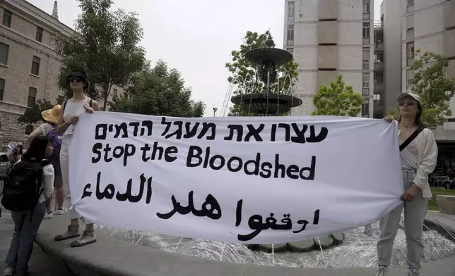 Activists hold a large banner in Arabic, English and Hebrew in Paris Square to call for a permanent ceasefire in the Gaza Strip, outside of the official residence of Israeli Prime Minister Benjamin Netanyahu in Jerusalem, Friday, May 10, 2024.(AP Photo/Maya Alleruzzo)